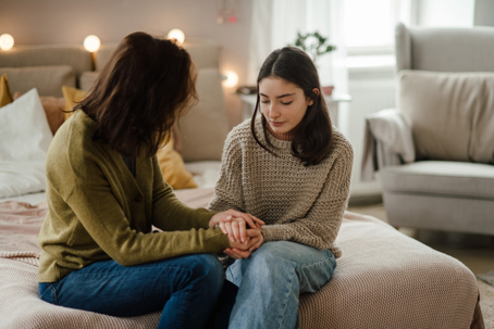 mother comforting teen daughter